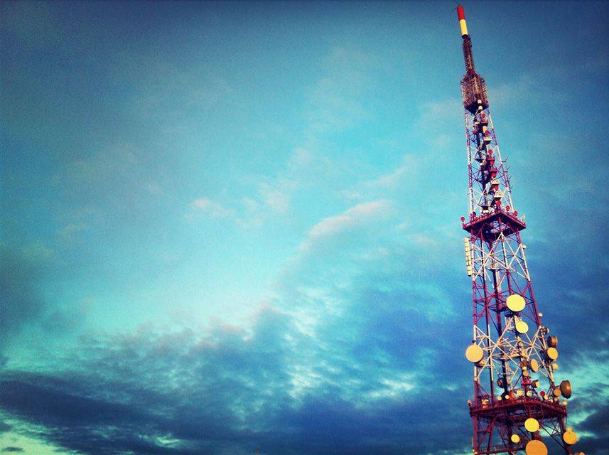 Torre emissora de ràdio contra un cel blau parcialment ennuvolat