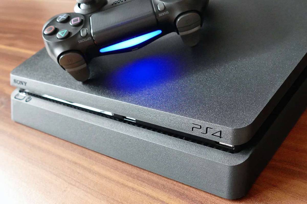 Playstation 4 dengan pengontrol pada permukaan serat kayu