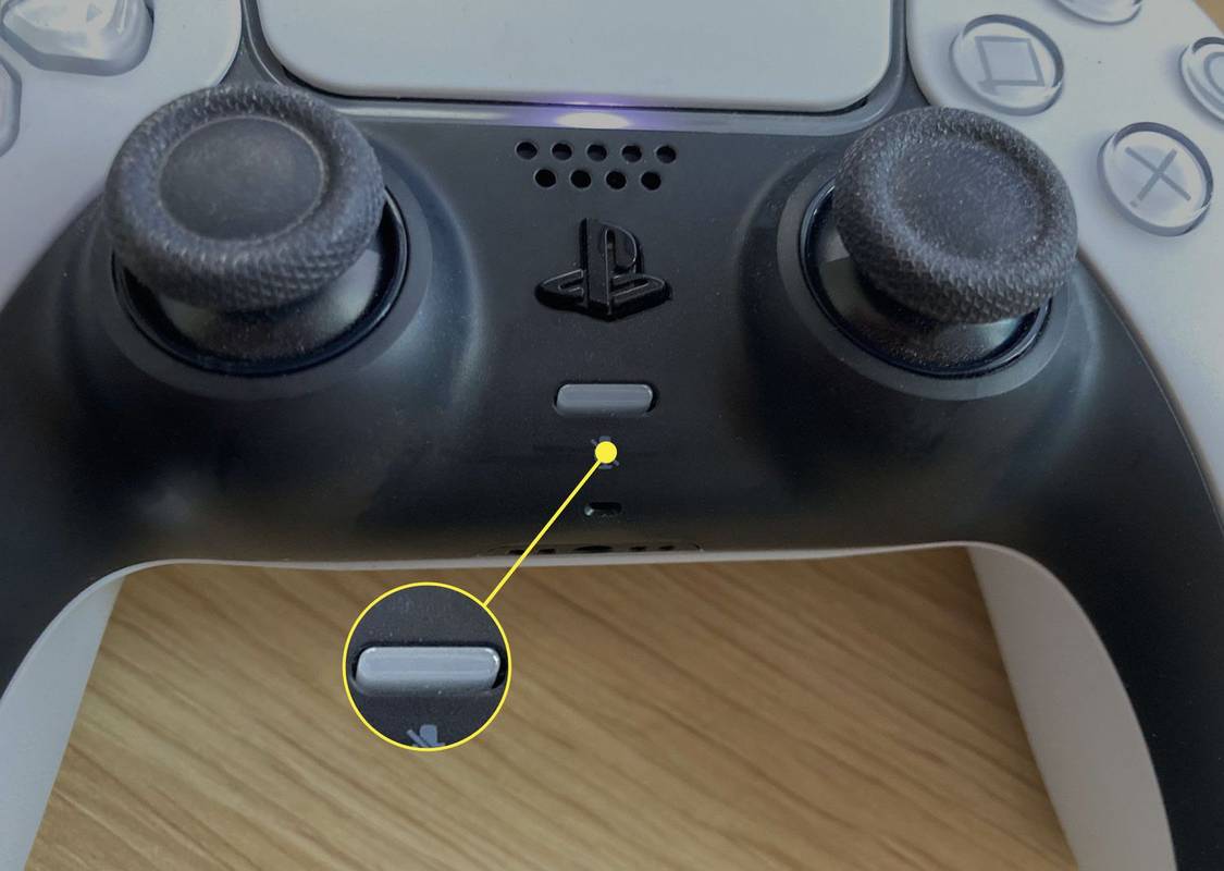 Το κουμπί μικροφώνου (δεν φωτίζεται) κάτω από το κουμπί PS σε ένα χειριστήριο PS5.