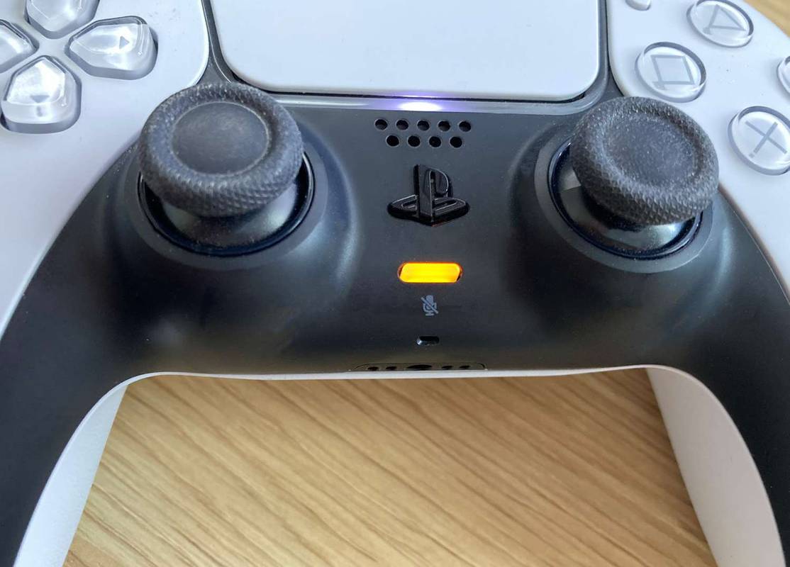 Το κουμπί μικροφώνου (πορτοκαλί φως) σε ένα χειριστήριο PS5.