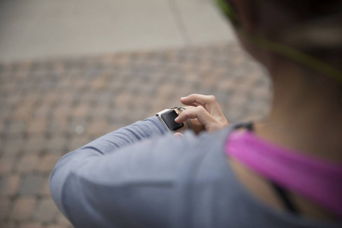 امرأة تستخدم الساعة الذكية أثناء الجري