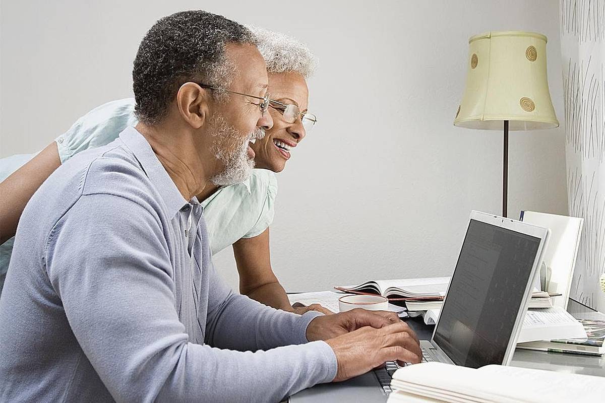 Couple dans leur bureau à domicile regardant un ordinateur portable.